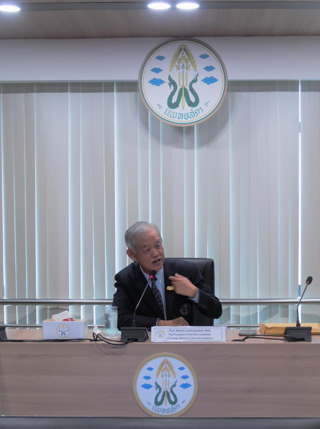 A man sitting at a table, focused on conversation or work, surrounded by everyday objects