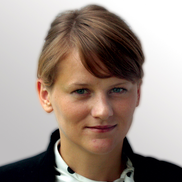 A woman with short brown hair smiles softly, showcasing her confident and approachable demeanor in a bright setting.