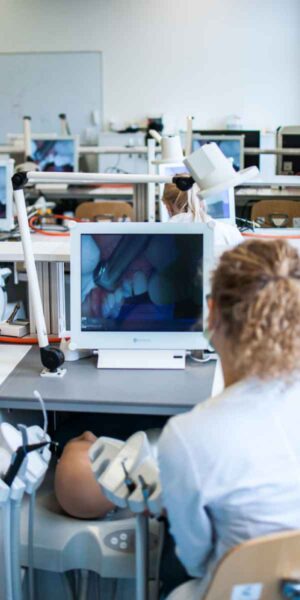 A dental assistant diligently working on a computer in a dental office, handling administrative tasks and patient information.