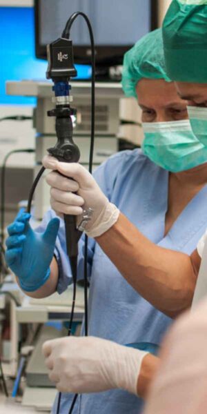 Two surgeons collaborate on a medical machine in a sterile operating room, focused on a critical procedure.