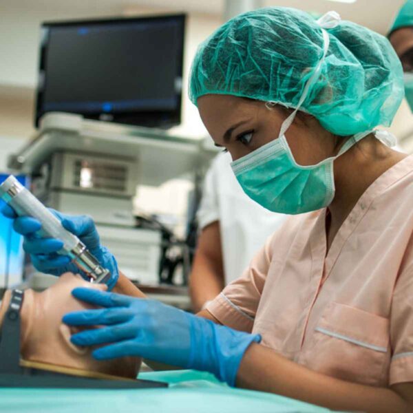 A nurse skillfully conducts an operation on a medical dummy, demonstrating surgical techniques in a training environment.