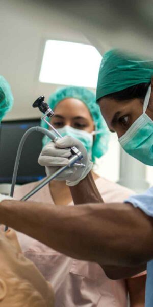 A team of surgeons skillfully performing procedures on a medical dummy head in a surgical training environment.
