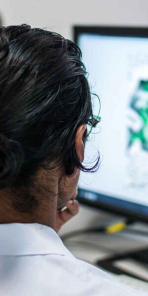 A scientist in a lab coat analyzes information displayed on a computer screen, reflecting her professional focus.