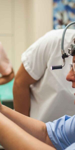 A healthcare professional uses a device to assess a patient, highlighting the importance of medical technology in diagnostics.