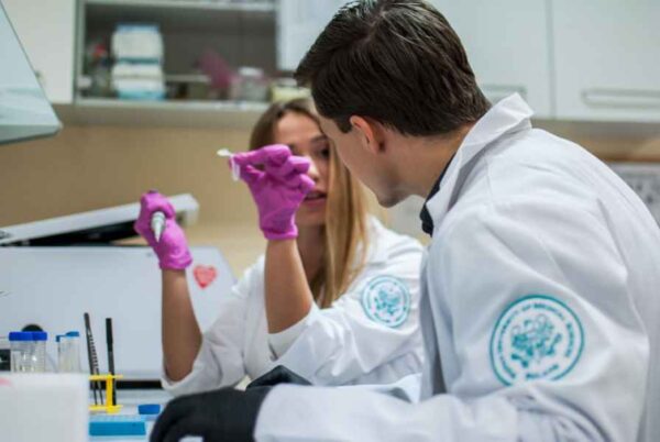 Two professionals in lab coats engaged in research activities within a laboratory environment.