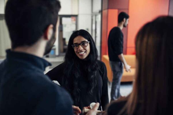 Several individuals conversing in an office environment, highlighting teamwork and communication among colleagues.