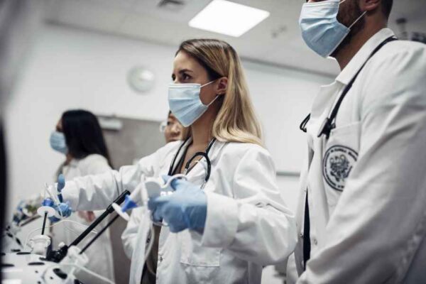 A close-up of medical students in a lab actively engaged in laparoscopic surgery simulation, with intense focus on mastering the techniques.