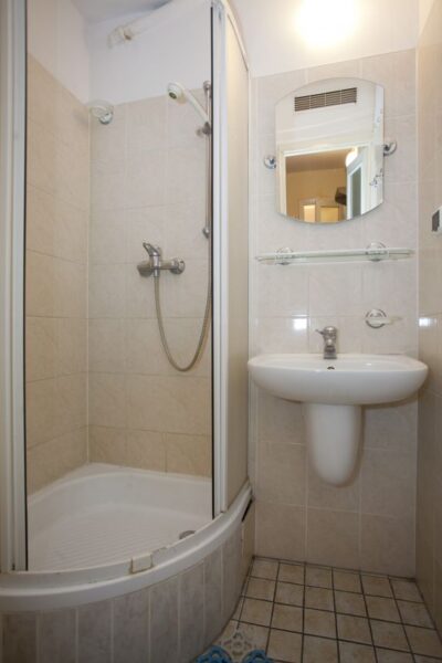 A clean bathroom featuring a shower, sink, and toilet, showcasing modern fixtures and a bright, inviting atmosphere.
