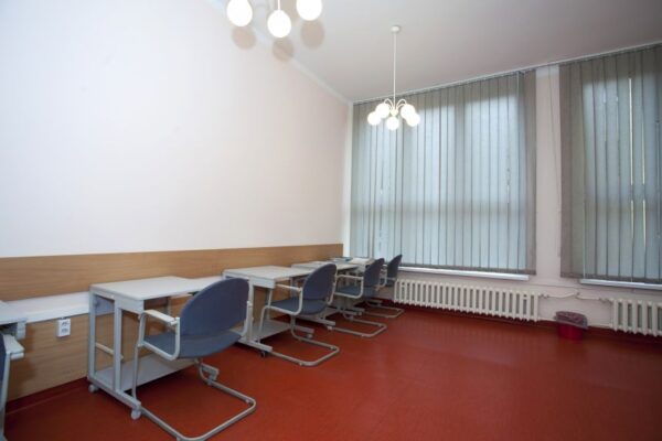 A classroom featuring neatly arranged desks and chairs, ready for students to engage in learning activities.