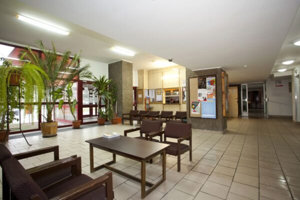 A spacious lobby featuring multiple chairs and tables arranged for seating and social interaction.