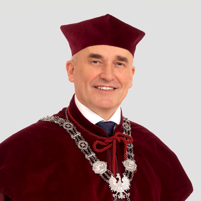 A portrait photo of a caucasian middle-aged man in full university regalia